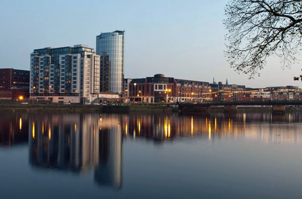 A view of the River Shannon in Limerick, Ireland, showcasing modern buildings and city lights