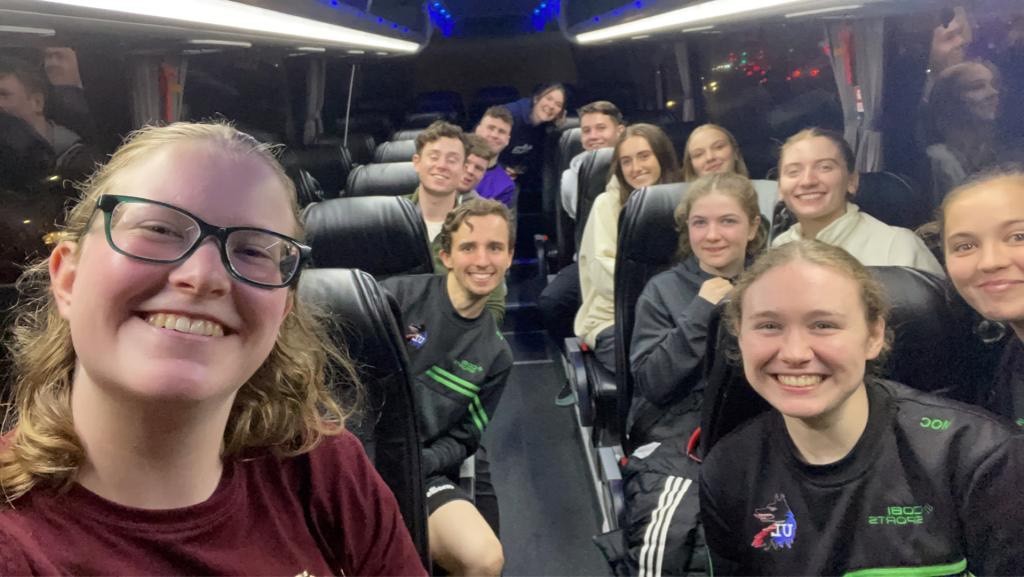 Jade smiling for a photo with her team mates on a bus after a hockey game