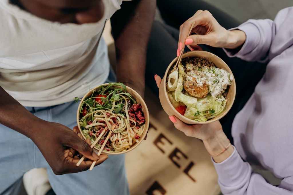 stock image of people holding bowls of food