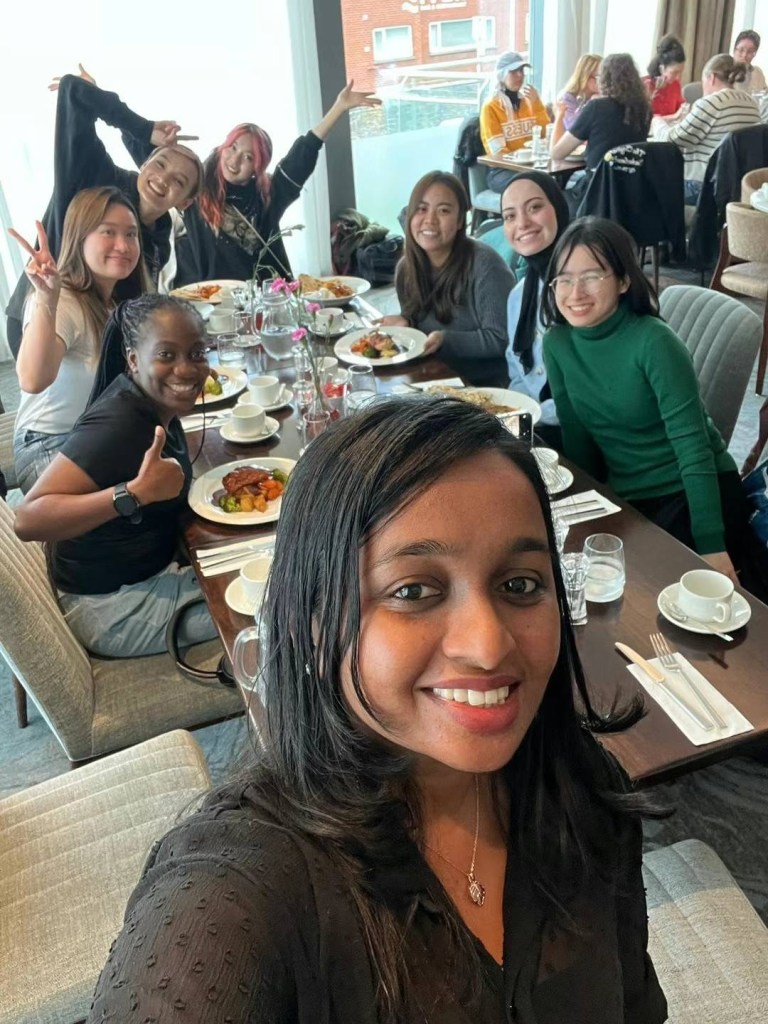 Aleena taking a selfie with Niri and other Ambassadors in the background