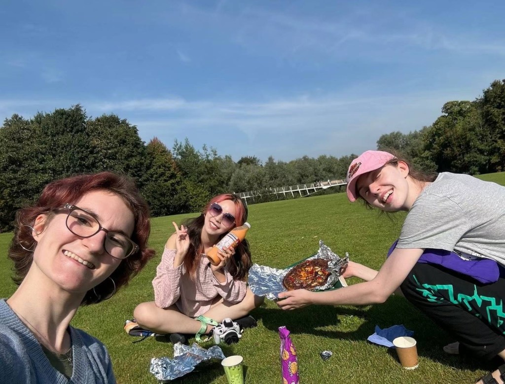 Niri and her friends eating on the lawn in front of the Living Bridge