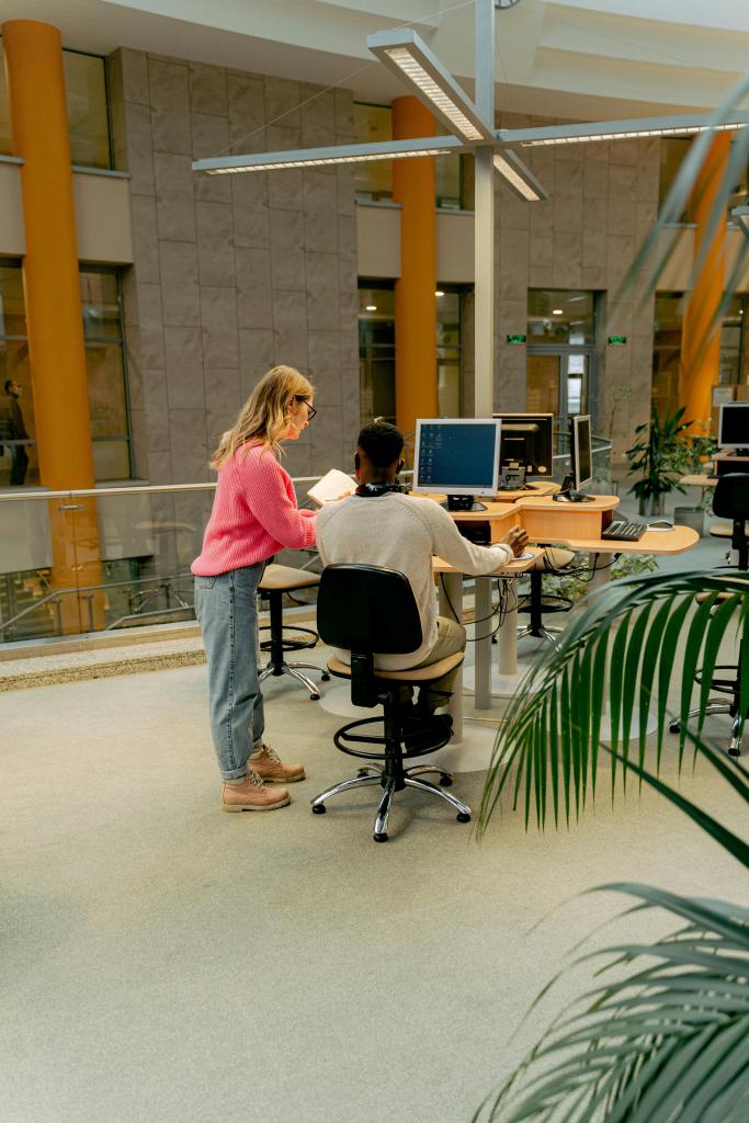 Two people using a computer in library 