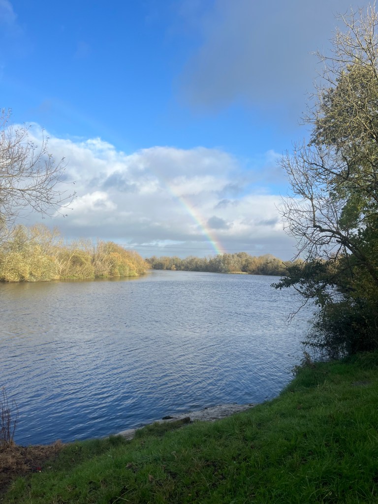 The river Shannon on a sunny day and a rainbow in the background
