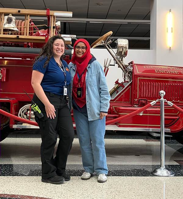 Maimoona and Alexis standing in front of an old service car