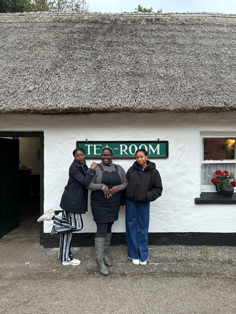 Three ambassadors standing in front of the tea room at the Folk Village