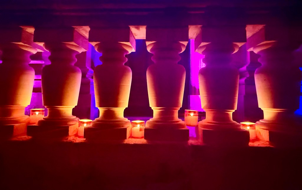 Candles peeking through a railing