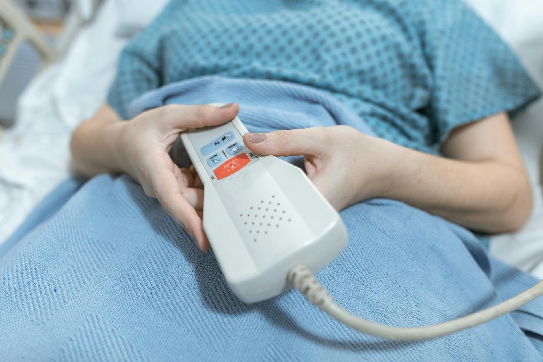 A close up on a patient holding the press button to call on nurses