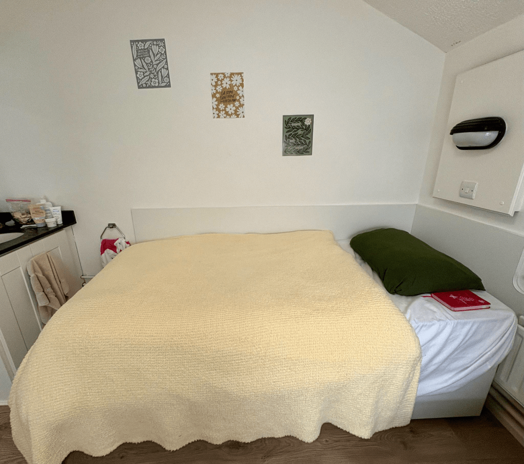Image of Katies beige blanket covering her bed in her bedroom.