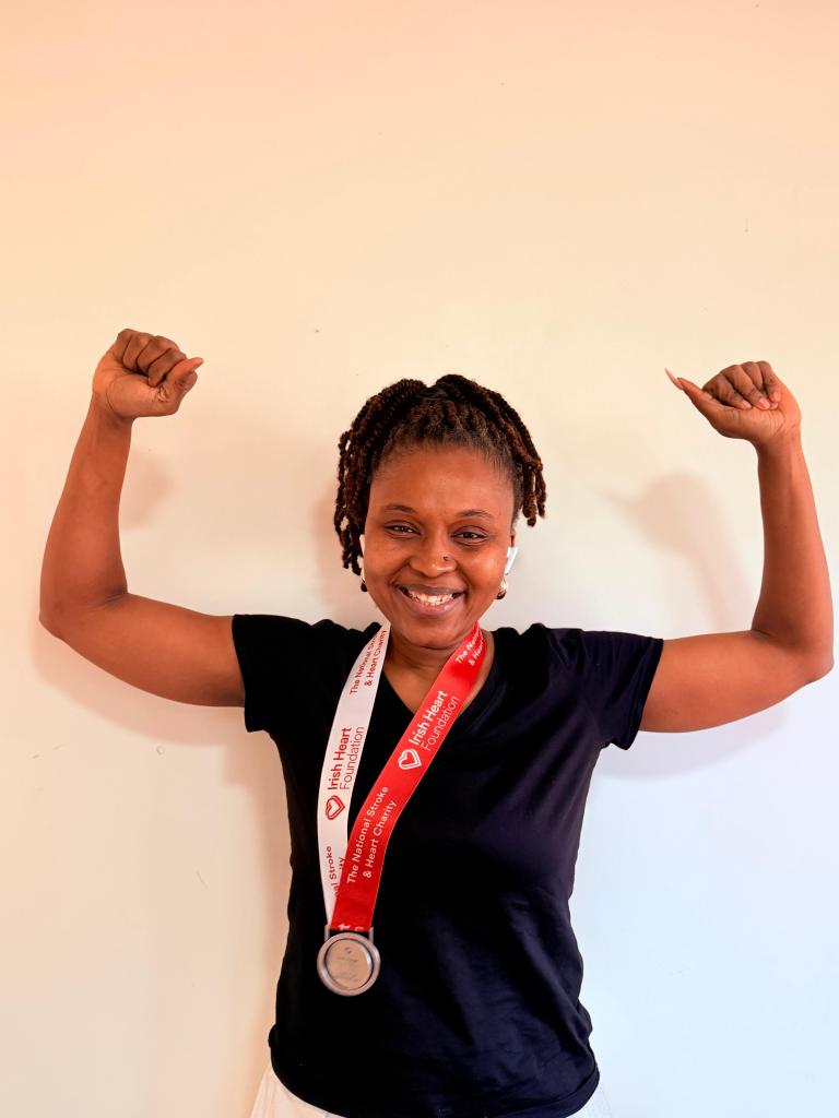Mariama holds her arms above her head in victory with the medal around her neck